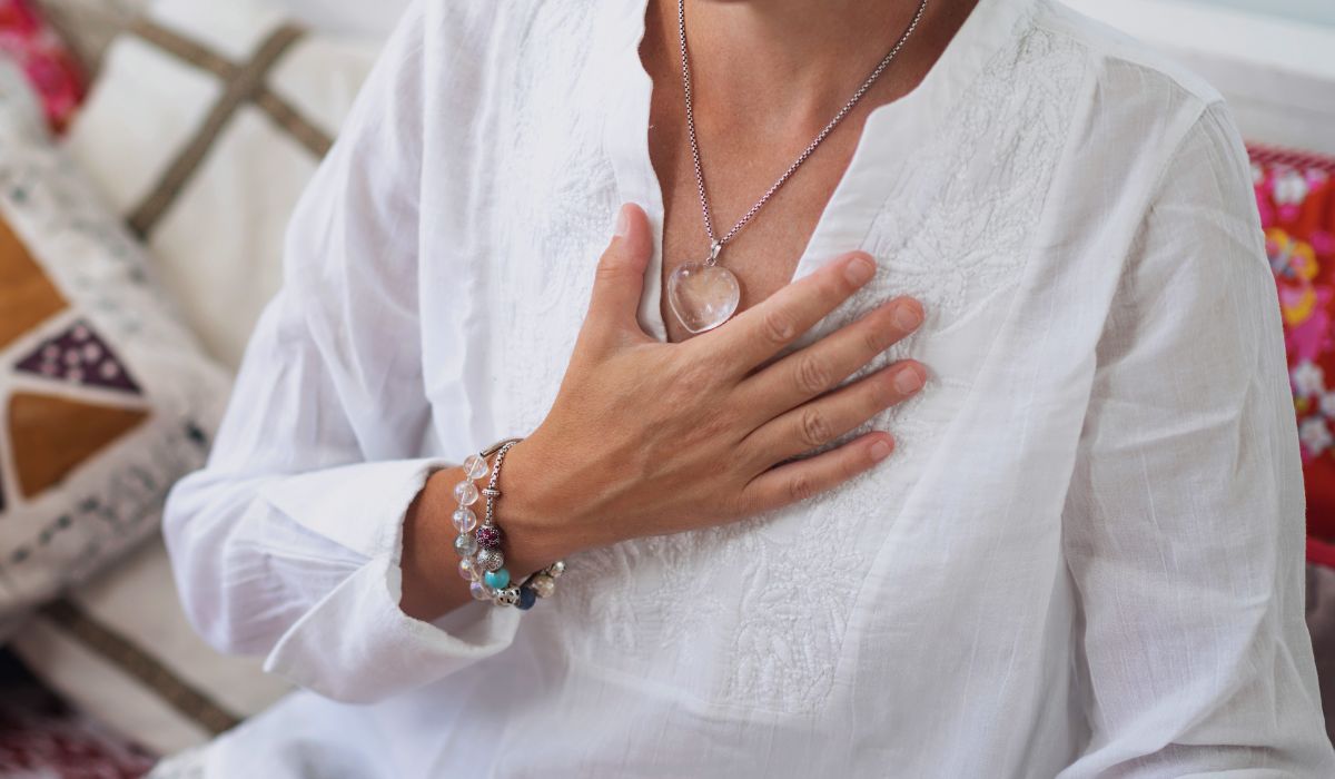 Woman holding heart, transforming suffering into wisdom.
