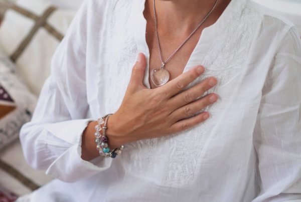 Woman holding heart, transforming suffering into wisdom.