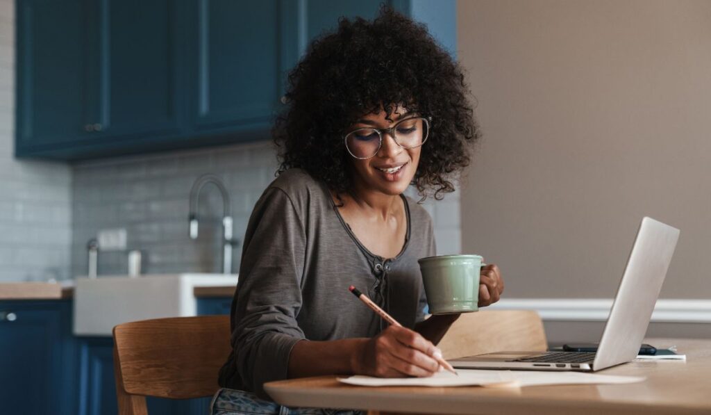 Woman working on her laptop for her life coach training program.