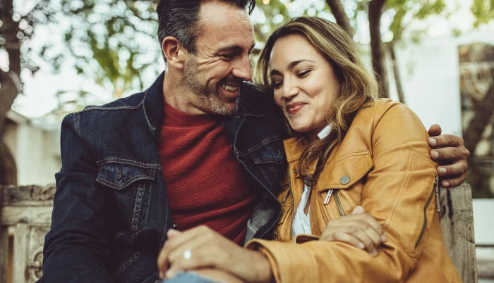 happy couple sitting on a park bench